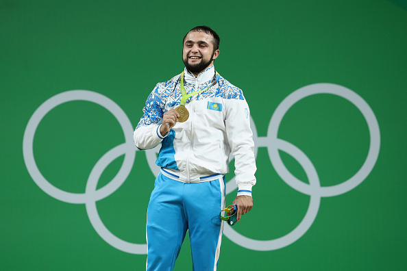 RIO DE JANEIRO, BRAZIL - AUGUST 10: Gold medalist, Nijat Rahimov of Kazakhstan celebrates on the podium after the Men's 77kg Group A weightlifting contest on Day 5 of the Rio 2016 Olympic Games at Riocentro - Pavilion 2 on August 10, 2016 in Rio de Janeiro, Brazil. (Photo by Julian Finney/Getty Images)